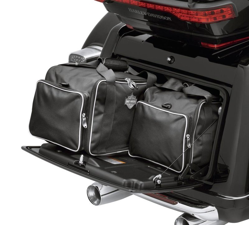 Harley-Davidson Accessories Trunk Travel-Paks. These well-constructed ballistic nylon bags are designed to fit perfectly into the rear or top-load trunk of the Trike models. Styled to complement the Premium Luggage Collection, the twin bags feature white piping and a reflective Bar & Shield logo, glove-friendly zippered access to the main compartment, and convenient outer pouches. Comfortable carrying straps make transport easy. Sold in pairs. Fits '09-later Trike models.
