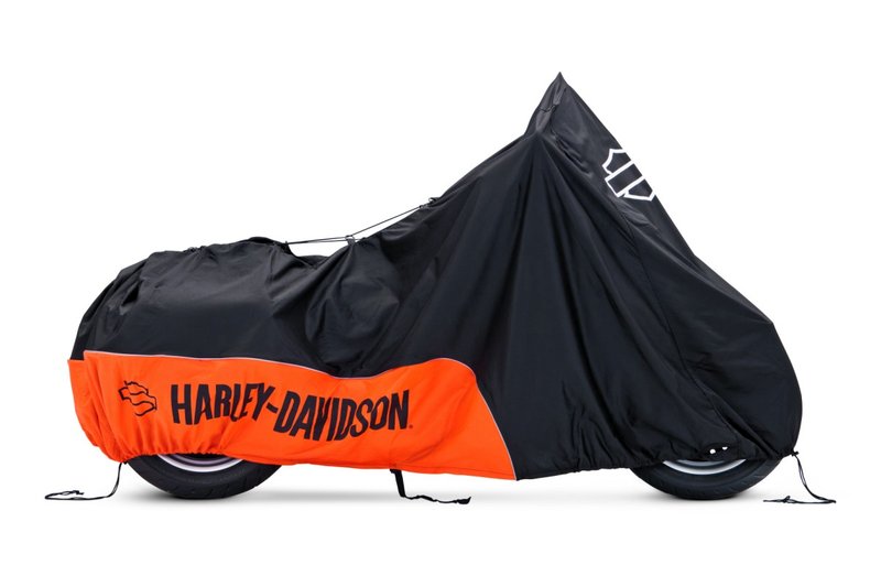 Harley-Davidson Accessories Protect your bike from dust and scratches. Perfect for a bike that's parked indoors, this breathable polyester cover promotes air circulation to reduce moisture build-up and minimize corrosion during short or long term storage. - Cover skirt features front and rear adjustable drawstrings to cinch the cover around the bike, and a convenient belly strap to reduce ballooning in the wind - The corset-style cinching system along the backbone lets you adjust the cover for best fit on a variety of models, and the hook-and-loop opening at the rear accommodates antennas - The two-tone orange and black cover features reflective piping for added visibility, and an integrated storage pouch for convenient packing when not in use