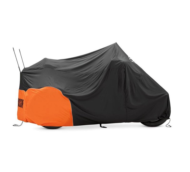 Harley-Davidson Accessories Pamper your bike. This luxuriously soft microfiber cover is ideal for short and long term indoor storage. - The breathable microfiber material promotes air circulation to reduce moisture build-up and minimize corrosion - Cover skirt features front and rear adjustable drawstrings to cinch the cover around the bike, and a convenient belly strap to reduce ballooning in the wind - The corset-style cinching system along the backbone lets you adjust the cover for best fit on a variety of models - The cover features heat-resistant panels that protect the material from warm exhaust, and the hook-and-loop opening at the rear of Touring and Trike covers accommodates antennas - The two-tone orange and black cover features reflective piping for added visibility, and an integrated storage pouch for convenient packing when not in use