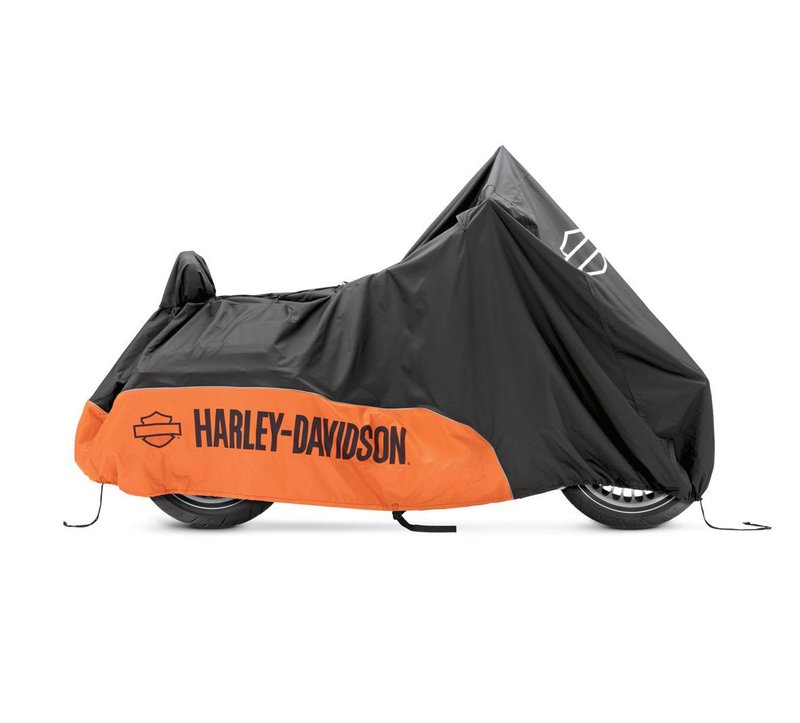 Harley-Davidson Accessories Guard your bike from Mother Nature. Perfect for a bike that is exposed to the elements, this heavy duty cover is manufactured from diamond-pattern 300 Denier fade-resistant polyester and features taped seams for water resistance. - The weather-shielded vents in the top of the cover promote air circulation to reduce moisture build-up and minimize corrosion during short or long term storage - Internal heat-resistant panels protect the cover from warm exhaust and an integrated storage pouch permits convenient packing when not in use - The cover skirt features front and rear adjustable drawstrings to cinch the cover around the bike, and a convenient belly strap to reduce ballooning in the wind - The corset-style cinching system along the backbone lets you adjust the cover for best fit on a variety of models, and the hook-and-loop opening on Touring covers accommodates antennas - Available in your choice of two-tone orange and black or inconspicuous plain black finish, the cover features reflective piping for added visibility