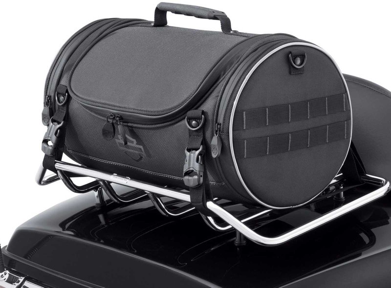 Harley-Davidson Accessories Onyx Premium Luggage Day Bag. Part of the Onyx Premium Luggage Collection, this compact Day Bag is ideal for the daily commute or a short day trip. The main compartment holds a sweatshirt, a pair of shoes, a rainsuit, gloves and a cap, while an interior mesh zip pocket keeps keys or small electronics handy. Its rigid structure keeps its shape even when empty, and the detachable padded shoulder strap makes it easy to carry. Made of premium 1680-denier UV-stable ballistic polyester that stands up to tough road and weather conditions without fading. Features water-resistant zippers with glove-friendly pulls, a burnt-orange interior for easy visibility, MOLLE-style webbing for modular pouch attachment, a non-slip abrasion-resistant base and reflective piping. Dimensions: 16.75" W x 9" D x 9" T. Capacity: 1,000 cubic inches (16 litres). Includes a removable shoulder strap and a rain cover with an elastic hem and barrel-lock mechanism that stays put at highway speeds. Fits models equipped with luggage racks (with or without a sissy bar upright) and Tour-Pak luggage racks (except Mini Rack P/N 53100-95).