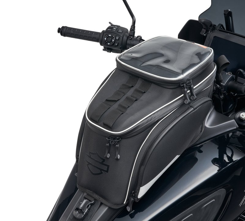 Harley-Davidson Accessories Keep essentials and a mobile device handy on the ride. Designed specifically for Pan America 1250 and Pan America 1250 Special models, the bottom of this tank bag is co-moulded to fit over the plastic cover on top of the fuel tank for a secure, custom fit. - Touch-sensitive window over the top pocket allows use of a mobile device stored in the pocket below - Water-resistant rain cover with a matching touch-sensitive window - A compartment designed to hold an auxiliary lithium battery is located below the device pocket and has a port for a charging cable - High-visibility orange interior makes it easier to see the bag's contents - Internal pockets and dividers help organise contents - Features a top carry handle and a leave-behind strap that secures the bag and can be tucked under the front of the seat when the bag is not in place - Luggage volume capacity: 8 litres - Luggage weight capacity: 5 pounds