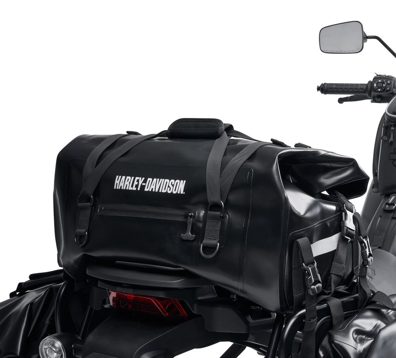 Harley-Davidson Accessories Adventure Duffel Bag. Intended for the hardcore off-road rider, this durable bag is designed for motorcycle use and resists damage if the bike tips over. The material is waterproof, the exterior pockets have waterproof zippers, and the roll-top closure creates a weather-tight seal so your gear stays dry in any conditions. The roll-top design and multiple compression straps let you cinch the load tightly for flexible capacity, and the bag is reflective for visibility in low light. The duffel can be secured to the Top Case Mounting Plate (sold separately) behind the seat, or on the passenger pillion in front of a hard case. Luggage capacity: 2,440 cubic inches (40 litres). Weight capacity: 22 lbs (10 kg). Size: 21" x 12" x 10". Includes universal mounting straps. Fits Pan America RA1250/S '21-later, and universal fitment.